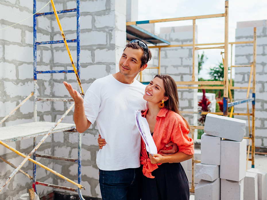 Para na budowie rozmawia o etapach budowy - w tle rusztowania