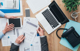 Business team working at office desk and analyzing financial reports, finance and accounting concept, top view